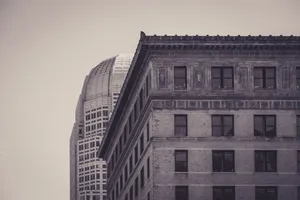 A sepia-toned photograph showcasing the contrast between historical and modern urban architecture. jigsaw puzzle