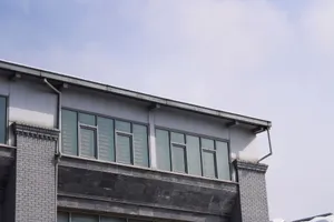A contemporary brick building featuring large glass windows under a clear sky. jigsaw puzzle