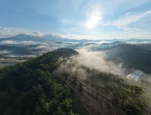 A breathtaking aerial view of mist-covered mountains and lush forests at sunrise in Vietnam, showcasing nature's serenity. jigsaw puzzle
