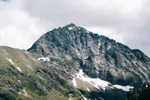 Breathtaking view of a snow-capped mountain peak under a cloudy sky, showcasing natural beauty. jigsaw puzzle