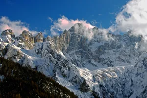 Majestic snow-covered mountains with a vibrant blue sky and clouds, showcasing winter's beauty. jigsaw puzzle