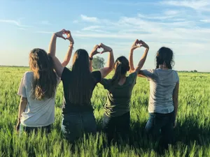 women forming heart gestures during daytime jigsaw puzzle