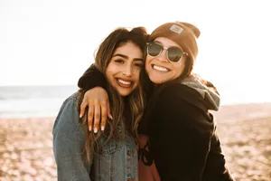 woman hugging other woman while smiling at beach jigsaw puzzle