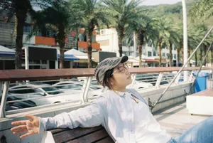 Person relaxing on a bench under palm trees. jigsaw puzzle
