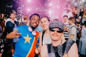 Three friends posing at a vibrant outdoor music festival. jigsaw puzzle