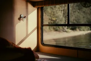 Sunlight streams into a camper window overlooking a lake. jigsaw puzzle