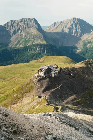 Alpine hut on a rocky mountain ridge with distant peaks. jigsaw puzzle