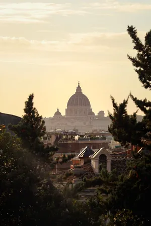Scenic view of St. Peter's Basilica at sunset surrounded by rooftops and greenery in Rome, Italy. jigsaw puzzle