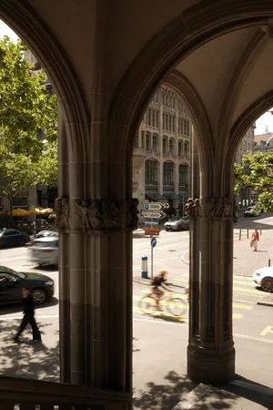 A view through stone arches onto a busy street in Zurich, Switzerland, featuring blurred cyclists and cars. jigsaw puzzle