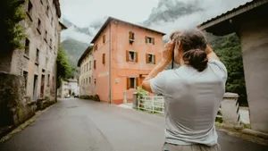 Man photographing historic buildings and misty mountains on a street. jigsaw puzzle
