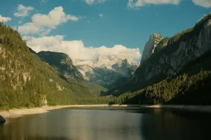 Lake surrounded by forested mountains under a blue sky jigsaw puzzle