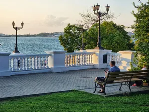 A man sitting on a bench next to a body of water jigsaw puzzle