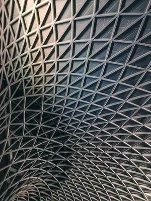 Intricate metal lattice ceiling at King's Cross Station, London, showcasing modern architectural design. jigsaw puzzle