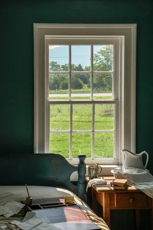 Tranquil scene of a cottage window overlooking a lush green landscape on a sunny day. jigsaw puzzle