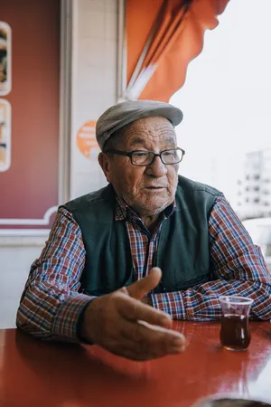 Elderly man in Ankara sitting at table, enjoying Turkish tea in a candid moment. jigsaw puzzle