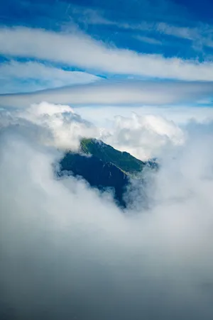 Majestic mountain peak in Reine, Nordland, Norway surrounded by clouds, creating a dramatic scene. jigsaw puzzle