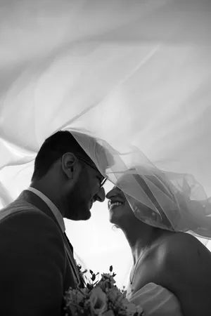Elegant black and white wedding photo capturing a tender moment under a veil. jigsaw puzzle