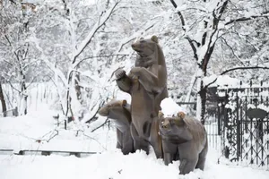 Statue of a bear family in a snow-covered park setting. jigsaw puzzle