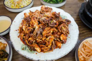 Close-up of a spicy Asian octopus dish with side dishes, showcasing vibrant flavors. jigsaw puzzle