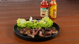 Succulent grilled octopus served with lettuce and hot sauce bottles, perfect for gourmet food enthusiasts. jigsaw puzzle