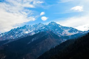 A stunning view of the majestic Dronagiri mountains covered in snow under a clear blue sky. jigsaw puzzle