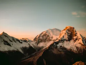 A breathtaking view of the Andean mountains, capturing the serene sunrise glow on snow-capped peaks. jigsaw puzzle