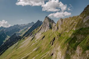 A stunning view of rugged mountain peaks under a clear sky, ideal for nature enthusiasts. jigsaw puzzle