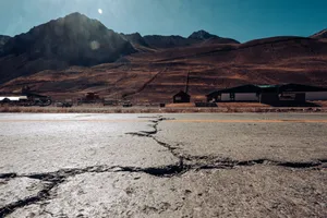 Cracked road leading to the Andes mountains in Mendoza, Argentina, under a clear sky. jigsaw puzzle