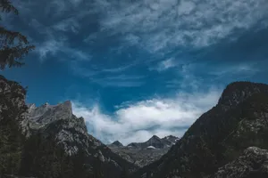 Low angle picturesque view of majestic mounts with trees under cloudy sky in daylight jigsaw puzzle