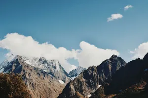 A stunning view of a snow-capped mountain range under a clear blue sky. jigsaw puzzle