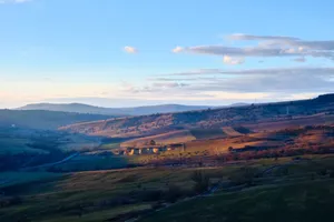 Beautiful landscape of rolling hills with soft sunset lighting and scattered clouds. jigsaw puzzle