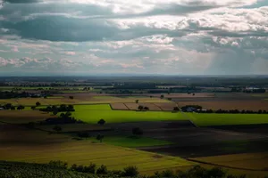 Dramatic clouds over a vibrant, agricultural landscape with patchwork fields. Perfect for nature and travel themes. jigsaw puzzle