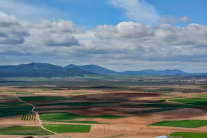Aerial view of vast farmland and hills in Consuegra, Spain, under a cloudy sky. jigsaw puzzle