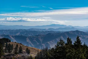 Beautiful panoramic view of mountain ranges with clear blue skies, perfect for travel and nature enthusiasts. jigsaw puzzle