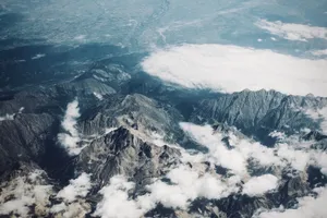 Drone shot of rugged mountain peaks covered by drifting clouds in a vast landscape. jigsaw puzzle