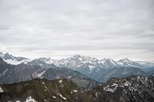 Breathtaking view of a snow-capped mountain range with cloudy skies. jigsaw puzzle