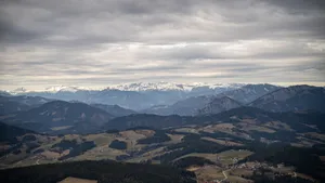 Aerial view of picturesque mountain range with snow-capped peaks under cloudy skies. jigsaw puzzle