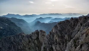 Capture of a tranquil mountain range at dawn with misty valleys and rocky peaks. jigsaw puzzle