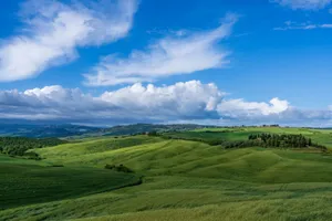 Beautiful landscape of green rolling hills under a vibrant blue sky in Tuscany, Italy. jigsaw puzzle