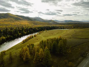 A picturesque view of a river winding through an autumn-colored forest and valley. jigsaw puzzle