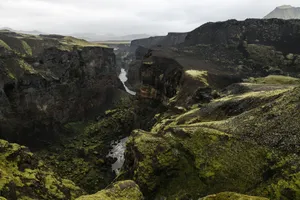 Breathtaking view of a lush moss-covered canyon with rugged cliffs and a winding river. jigsaw puzzle