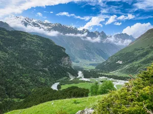 Breathtaking mountain landscape featuring a river meandering through a lush green valley. jigsaw puzzle