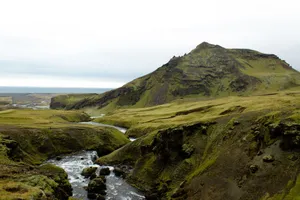 Stunning view of Iceland's rugged mountains and flowing river with green plains. jigsaw puzzle