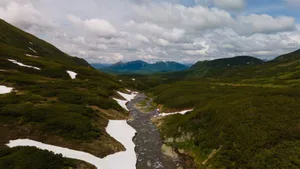 Breathtaking aerial view of a river valley with melting snow and green hills in Kamchatka, Russia. jigsaw puzzle