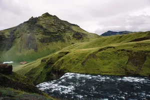 Breathtaking aerial view of a waterfall cascading down lush green hills in Iceland. Ideal for nature lovers. jigsaw puzzle