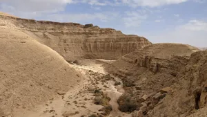 A breathtaking view of an arid desert canyon under a clear blue sky, showcasing nature's raw beauty. jigsaw puzzle