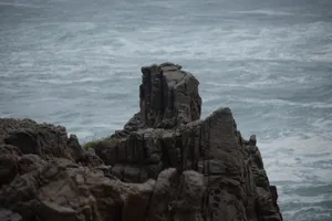Majestic rocky cliff formation against the powerful ocean waves. jigsaw puzzle