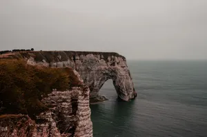 Beautiful coastal arch formation with ocean backdrop under a cloudy sky. jigsaw puzzle