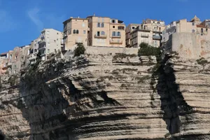 Scenic view of Bonifacio's stunning cliffside architecture under a clear blue sky. jigsaw puzzle