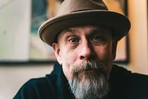 Close-up portrait of a mature man with a beard wearing a fedora hat, evoking a vintage style. jigsaw puzzle